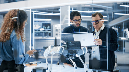 Professional Multicultural Team of Female and Male Engineers Work On Industrial Programmable Robot Dog in a Factory Development Workshop. Tech Facility with Machines, Computers and Research Equipment.