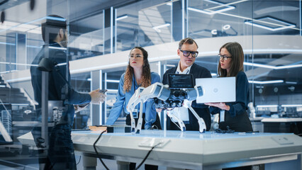 Professional Multicultural Team of Female and Male Engineers Use Industrial Programmable Robot Animal in a Factory Development Workshop. Tech Facility with Machines, Computers and Research Equipment.