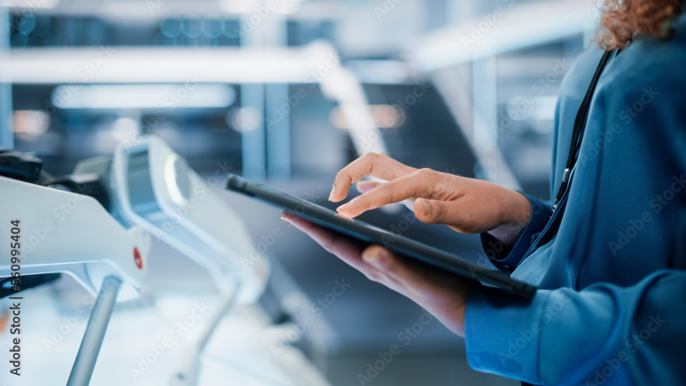 Poster close up footage of a female holding and using tablet computer in high tech modern industrial office
