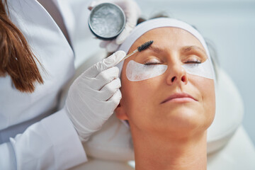 Woman having cosmetology eyebrows treatment in beauty salon