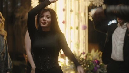 beautiful young woman has fun in Christmas corporate party in restaurant, men and women dancing
