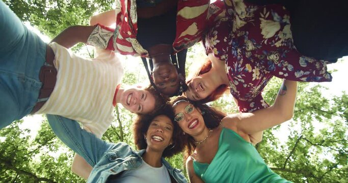 Low Angle: Group of Multiethnic Women Forming a Circle and Turning Around the Camera Outdoors. Young Diverse Female Friends Dancing Around the Camera and Looking at it, Being Playful and Having Fun 