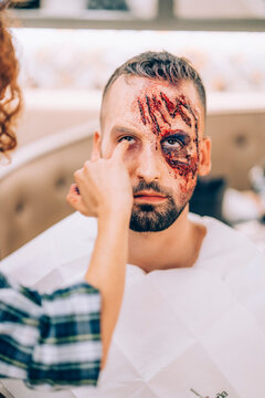 Man with makeup on his face with wounds and blood.