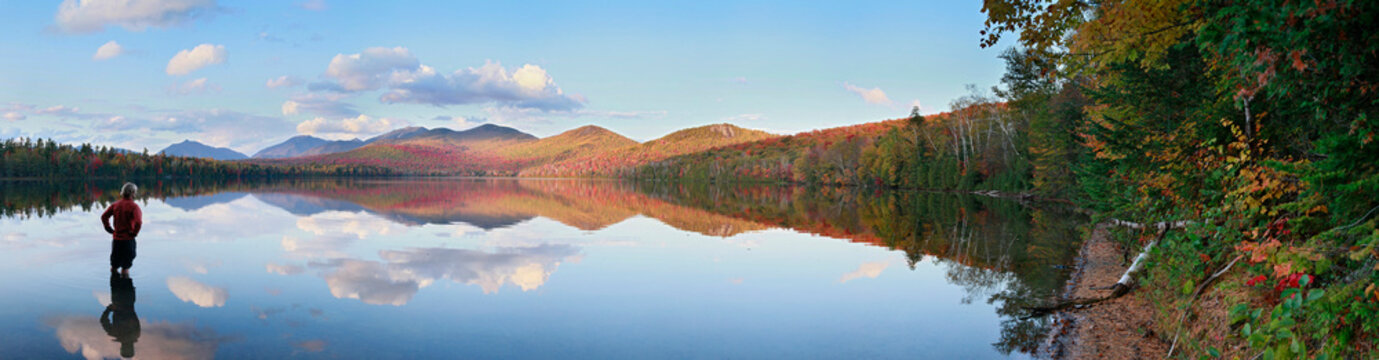 Wading in Clear Pond with reflections of the Dix Range, Elk Lake region, Adirondack Park, NY, USA