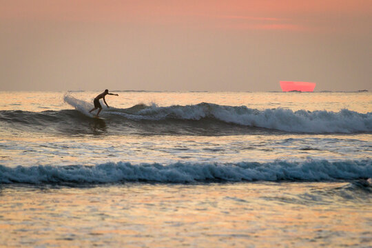 A man surfing in the Ocean.