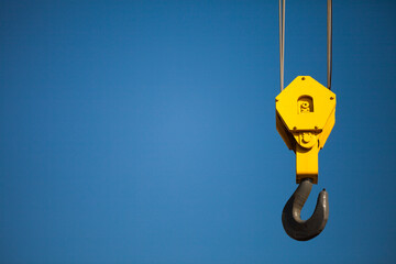 Crane hook against clear blue sky