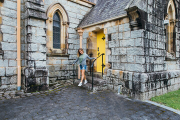 A girl on the steps of old Australian church