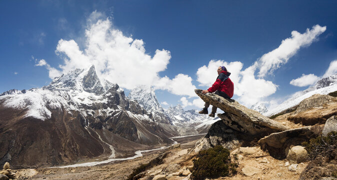 A trekker enjoys the views of Taboche and Cholatse along the trail to Everest, Khumu region, Himalaya Mountains, Nepal.