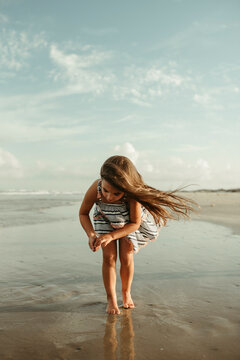 Little Girl looking for shells on the beach in Corpus Christi Texas