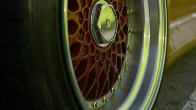 Shiny red, chrome and gold stud wheel alloy at stylish classic car fan meeting, Barcelona