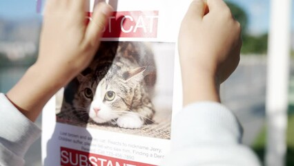 Schoolboy putting up missing pet banners.