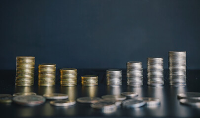 Stack of golden and silver money con on black background. Business and finance background.