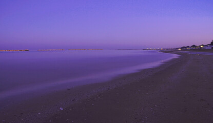 magenta tint sunset on the beach with calm sea