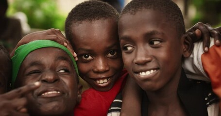 Close Up Of the Faces of a Group of Rural African Young Boys Smiling, Laughing and Posing for Camera. A Group of Expressive Black Male Friends Enjoying Their Childhood and Joking Around Together