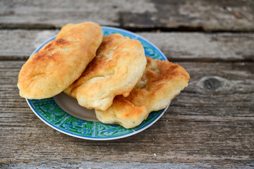 Traditional Bulgarian home made deep fried  patties  covered with sugar  оn rustic backgroud.Mekitsa or Mekica,  on wooden  rustic  background. Made of kneaded dough that is deep fried 