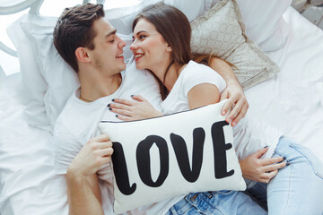 Happy attractive couple in love enjoying spending time together in bed. Celebrating Saint...