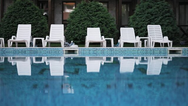Lounge chairs near a luxury swimming pool at a tropical resort spa
