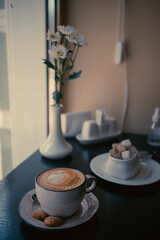 A cup of cappuccino with cookies