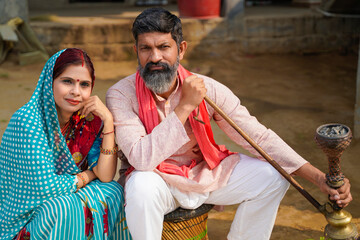 Indian rural man smoking traditional hukka at home.