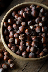 Shelled hazelnuts in bowl on a wooden table.