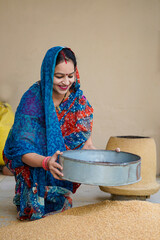 Indian rural woman cleaning wheat at home