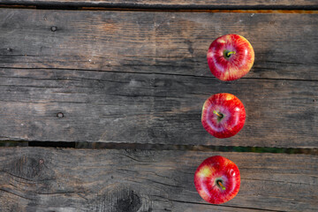 Ripe red apples on wooden background .