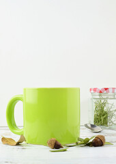 Winter concept, green mug on white and wooden background, copy space.	