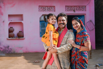 Happy indian farmer with wife and daughter at home.