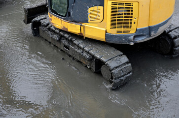 removing sedimentary sludge from the bottom of a pond or a swimming lake in the village. the muddy...