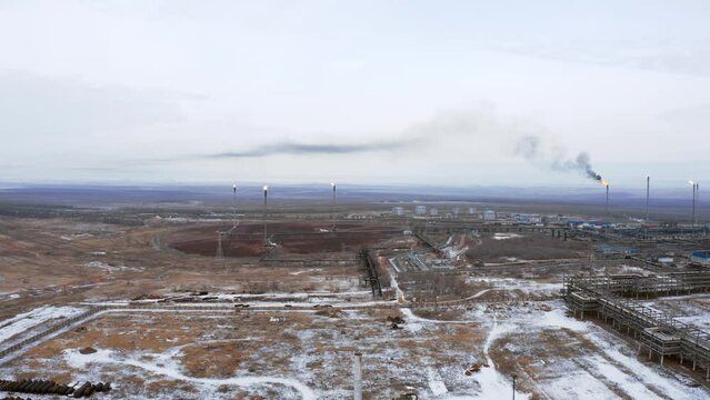A complex of burning high-altitude torches at a gas production and processing plant. Flying directly on a drone at the MCC