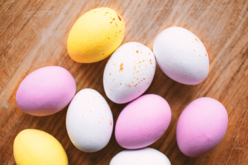 Colorful chocolate Easter eggs on wooden background with copy space