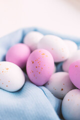 Colorful chocolate Easter eggs on blue background with copy space