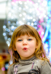 Fototapeta na wymiar Amazed portrait of a little girl in the middle of Christmas lights