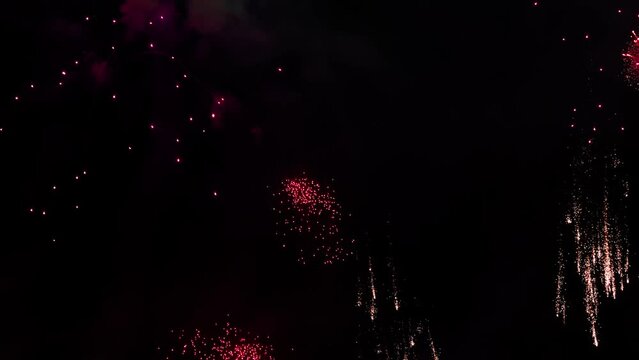 Colorful fireworks festival. Beautiful sparkling fireworks close-up view in slow motion. Wonderful real fireworks in the night sky shot with a telephoto lens. fireworks show. 4K slow motion video.