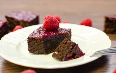 Fototapeta na wymiar Chocolate brownies with raspberries on white plate 