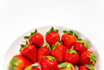 白い皿に盛られた赤いイチゴ
