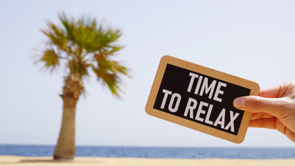 Fototapeta premium Time to relax is shown using the text and the photo of the palm on the beach