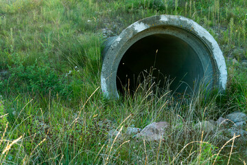 A large concrete pipe for diverting the river under the highway. Leaky dirty water from large concrete pipes. Dirty sewage from the pipe, environmental pollution. Environmental problem