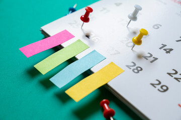 close up of pin on calendar on the green table background, planning for business meeting or travel...