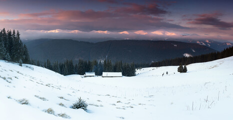 Amazing panoramic landscape  winter mountains at sunrise. View of dramatic overcast sky and distance snow capped peaks. Carpathian mountains range. Europe.