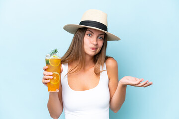 Young beautiful woman holding a cocktail isolated on blue background making doubts gesture while lifting the shoulders