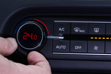 Set up air conditioner in the car. Hand turns air conditioner ring. Display indicates 24.0 degree...