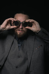 Obraz premium charismatic man in a classic suit and steampunk goggles on a black background stylish Portrait