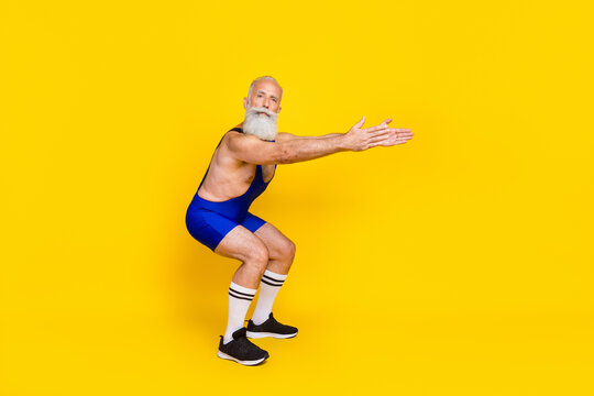 Full length photo of old senior coach sitting preparation flexibility warmup training professional bodybuilder advert sport app isolated on yellow color background