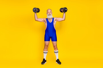 Full length photo of senior sporty professional trainer muscular arm raise heavy barbell wear suit isolated on yellow color background - obrazy, fototapety, plakaty