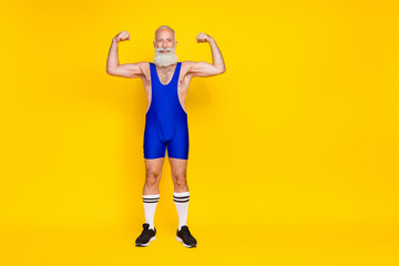 Fototapeta na wymiar Full length photo of cheerful funky senior masculine man trainer demonstrate power stand empty space isolated on yellow color background
