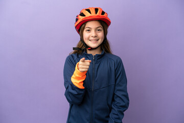 Little caucasian girl isolated on purple background surprised and pointing front