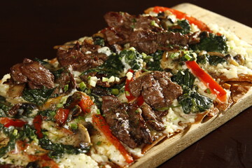 Crispy flatbread with steak, cheese and vegetables