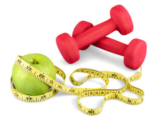 Green apple with a yellow measuring tape and Weights