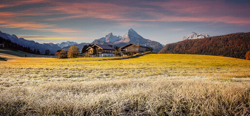 Fototapeta na wymiar Amazing nature landscape. Incredible autumn scenery. View on Alpine highlands with grassy hils and Watzmann mount during sunset. Berchtesgaden land, Bavaria Alps, Germany. Popular touristic location.